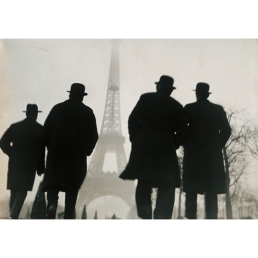 Quatre hommes de dos regardant la tour eiffel